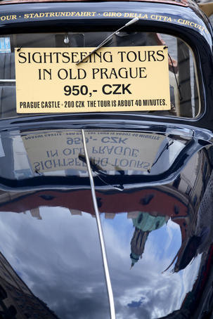 Sightseeing tour sign on windscreen of old car.