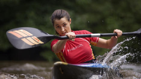 Female white-water kayaker training.