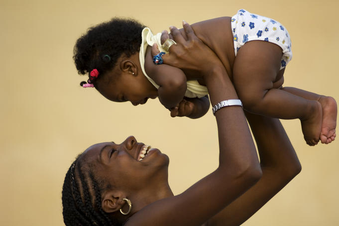 Young Cuban woman playing with her baby.