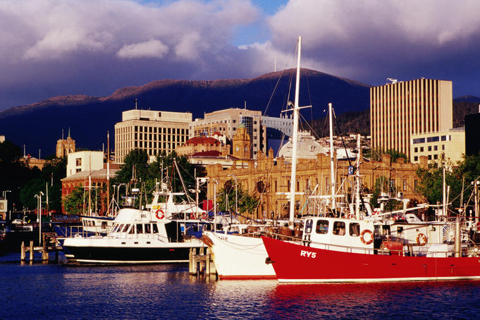 Boats at Victoria Dock with city buildings and Mount Wellington in background.