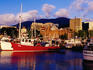 Boats at Victoria Dock with city buildings and Mount Wellington in background.