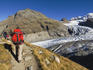 Hikers on a path with Vadret Pers, a side glacier and main Morteratsch glacier in background.