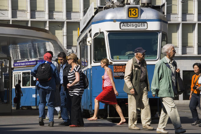 People and tram on affluent Paradeplatz.