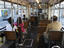 Passenger on wooden seats in an old Be 4/6 tram.