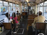 Passenger on wooden seats in an old Be 4/6 tram.