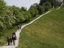 People hiking on a path through a meadow near the top of Mount Schauenberg, Schlatt.