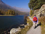 Hiker with a red pack walking on path along Champfersee (lake), Champfer.