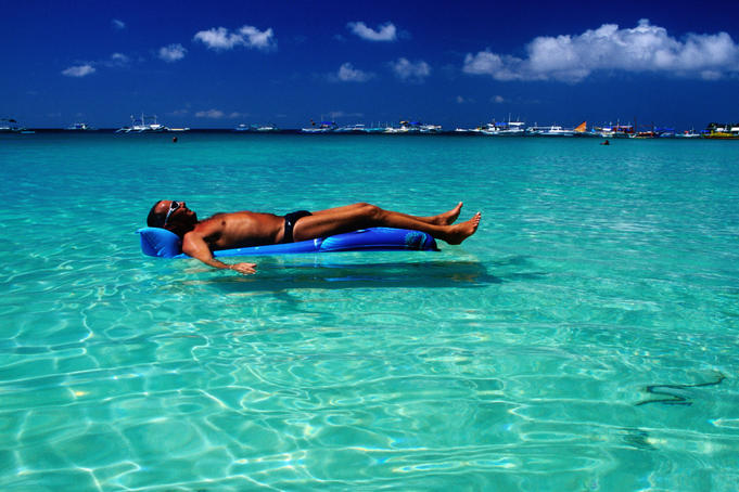 Tourist floating on airbed, White Beach.