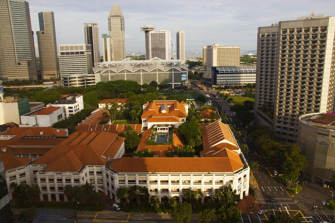 Overhead of historic Raffles Hotel and Singapore skyline.