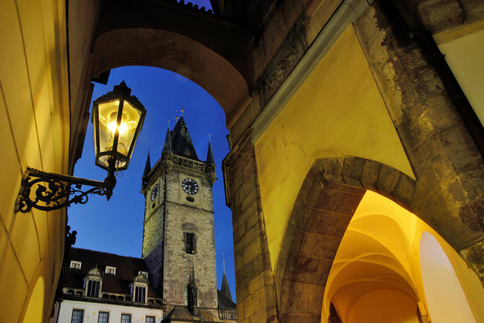 Astronomical Tower at dusk framed by arcade arch and lamp.