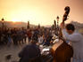 Tourists surround busker's near Charles bridge at sunset.