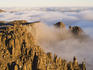 Mist around the dolerite cliffs and spires of Mt Field West at sunset.