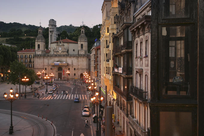 Streetlights, church and streetscape at sunset near Plaza Santiago, Bilbao