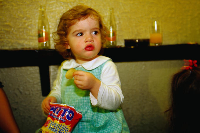 A young girl tucks into a packet of crisps - Dublin, County Dublin