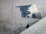 Man walking past a mural on Western Australian Maritime Museum, Victoria Quay.