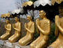Statues kneel in prayer before the Buddha at Phnom Sampeu.