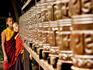 Two young monks behind prayer wheels.