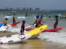 Lifesavers entering the sea with surfskiis, surf lifesaving carnival.