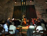 Band playing piano, double bass and drums to audience, Agharta Jazz Club.