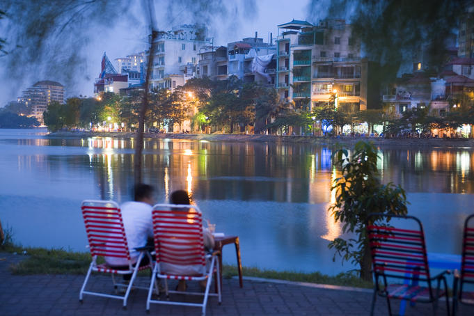 People relaxing beside Truc Bach Lake, West Lake & Truc Bach district.