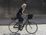 Woman riding bicycle on cobbled street.