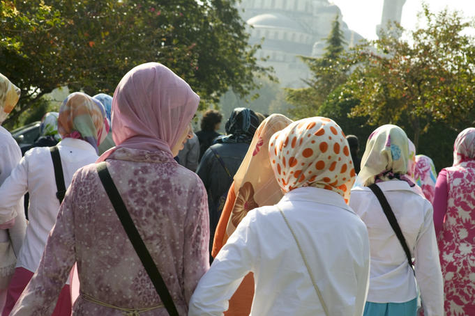 Women in scarves visit mosque.