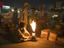 Shop owner gets a lamp burning for the night markets.