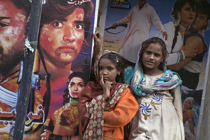 Young girls in front of movie posters.