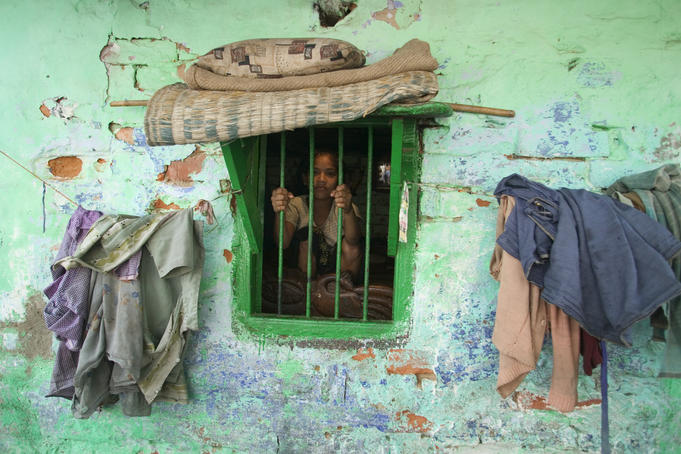 Girl looking out the window of her house.