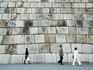 People walking past the massive stone wall of Tenshudai Donjon in Higashi-gyoen (Imperial Palace East Garden).