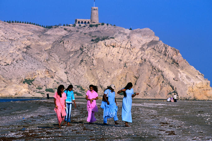 Indian girls walking on beach.