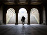Man walking through archway of underpass near Bethesda Fountain, Central Park.