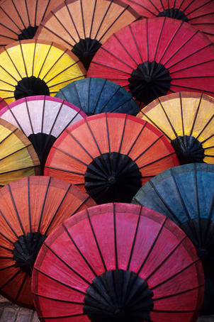 Lacquered umbrellas for sale at evening street market.