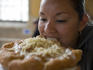 Woman biting into langos bread in Central Market Hall.