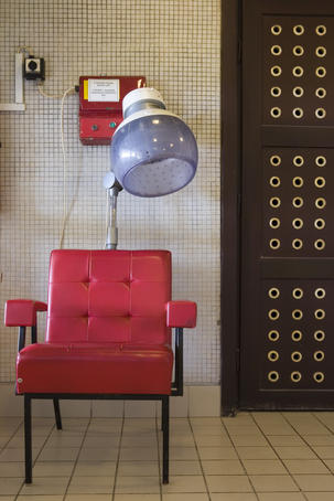 Red chair and coin-operated hair dryer at Gellert Baths.