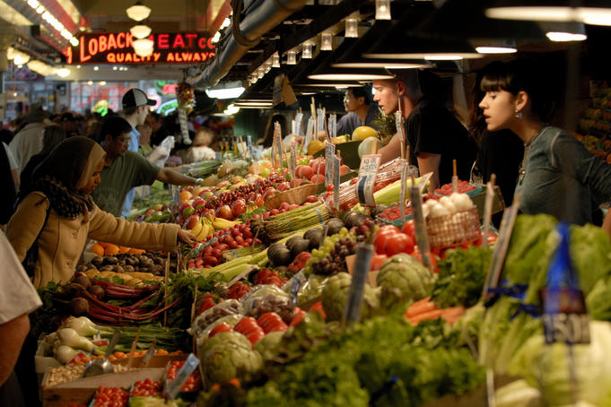 Customers inspecting fresh produce at Pike Place Market.