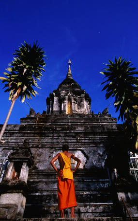 Monk standing on the steps of Wat Manolom.