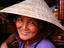 Portrait of elderly Vietnamese woman wearing traditional conical hat.