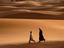 Men walking across sand dunes, Morocco