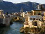 Reconstructed Old Bridge spanning the Neretva River with reconstructed buildings and mosques of the Ottoman/Turkish quarter in background.