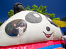 Young girl looks out from inside a giant inflatable panda ride.