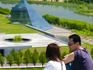 Couple at the summit of Mount Moere, with the glass pyramid (designed sculptor Isamu Noguchi) in the background.