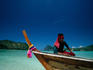 Traditional long boat in the waters of Ko Phi-Phi Don, Phi-Phi is the larger of two islands and comes with scenic hills, awesome cliffs, long beaches and emerald waters