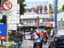 Motorbikes and cars on a busy road leading into the city centre.