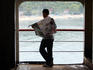 Man reading a newspaper on the Bali-Lombok ferry.
