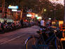 Line of motorbikes and street vendor at sunset.