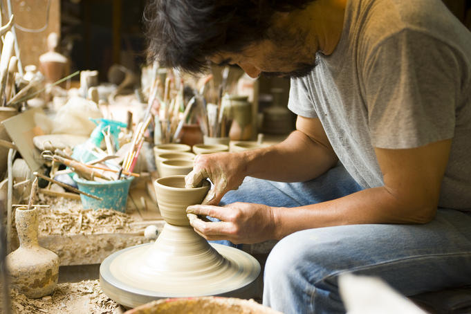 Potter making pottery bowls on a potter's wheel at Kageyama Pottery.