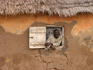 Villager iin window of mud and thatch house, near Walawale.