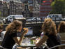 Patrons sit along Kloveniersburgwal canal at Cafe De Jaren in central Amsterdam.