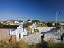 Small beach huts in dunes by the beach.